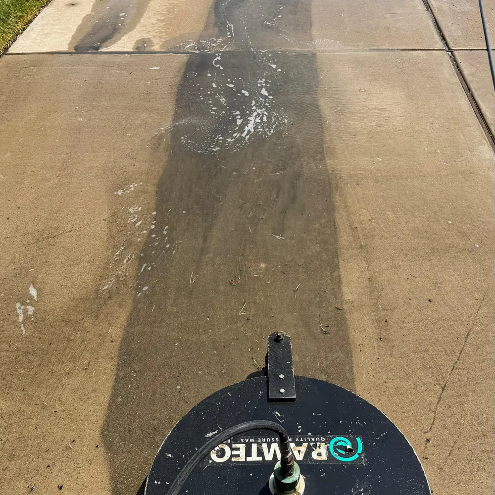 Driveway mid-clean, the washed half much lighter than the rest