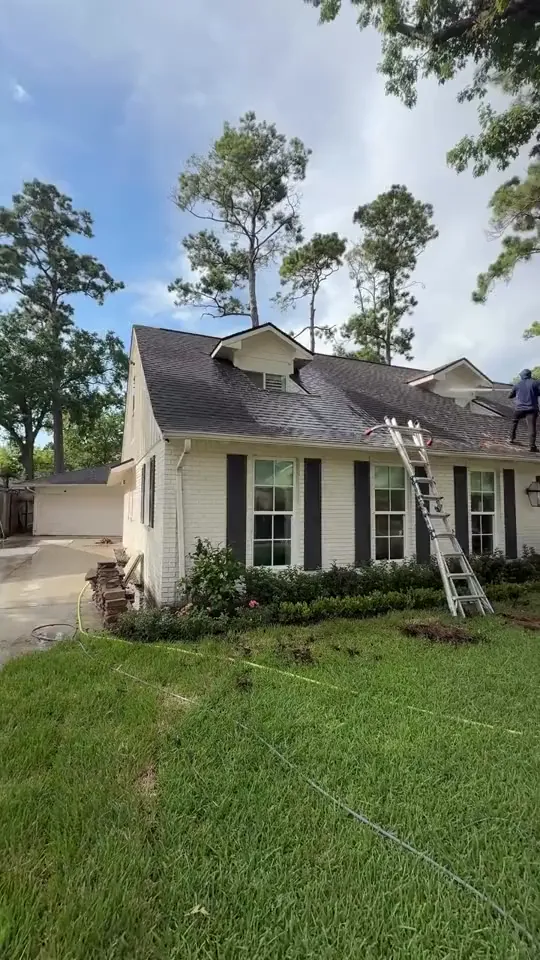 Ladder set against a two-story house at the roof line